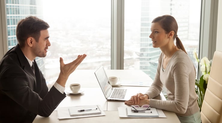 businessman-and-businesswoman-discussing-work-at-office-desk